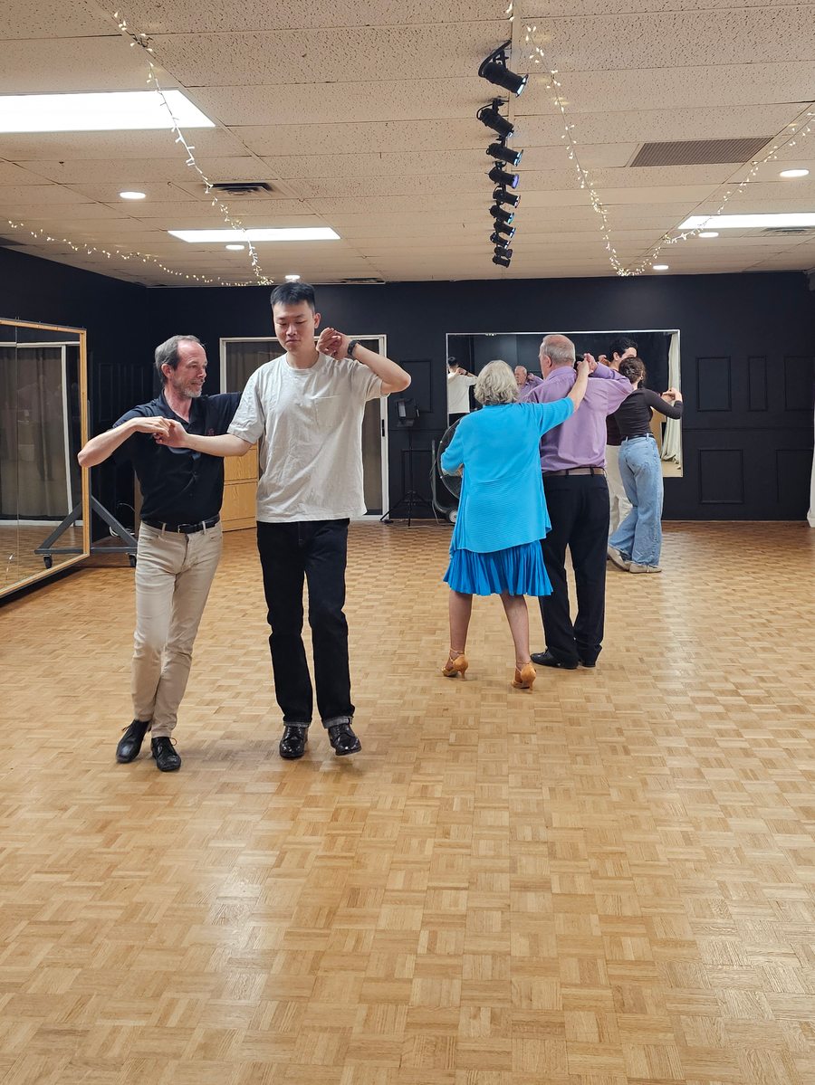 Several partnerships practising together in a dance class