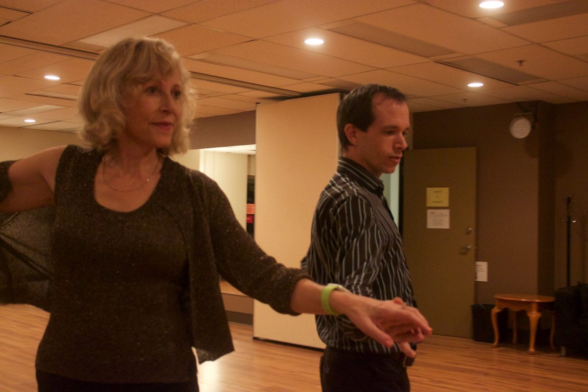 Two dancers practicing an extended arm movement