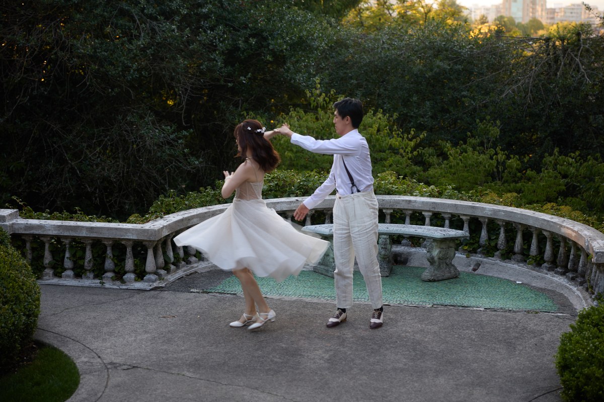 A wedding couple turning together on an outdoor terrace