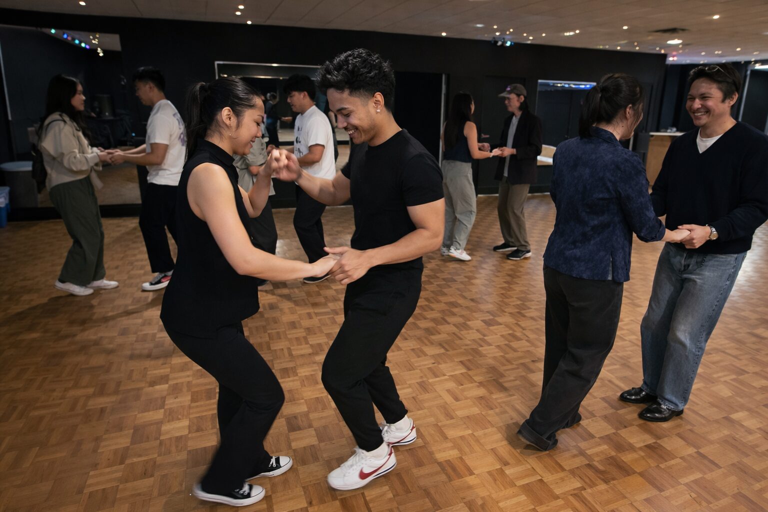 Dance students smiling and enjoying a partner dance lesson in Vancouver