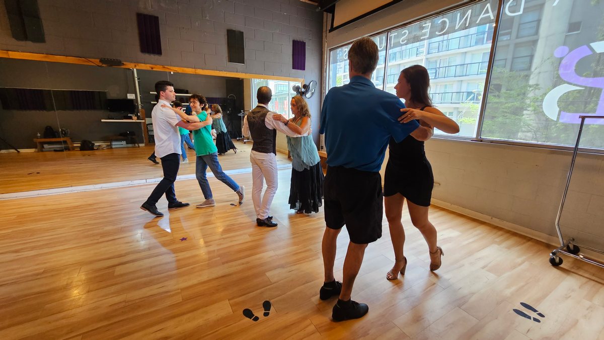 Couples practicing partner movement in a group class
