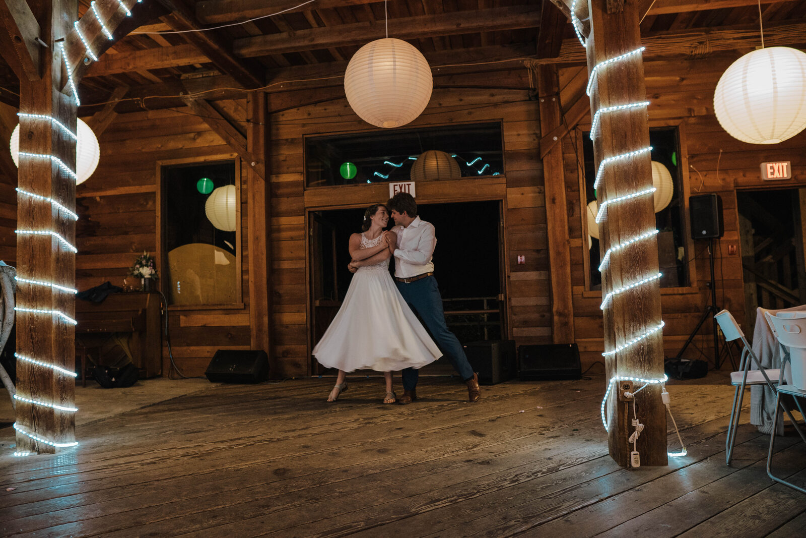 Wedding couple dancing together in a rustic reception venue
