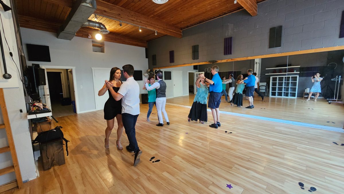 A wide view of partners practicing in a dance class