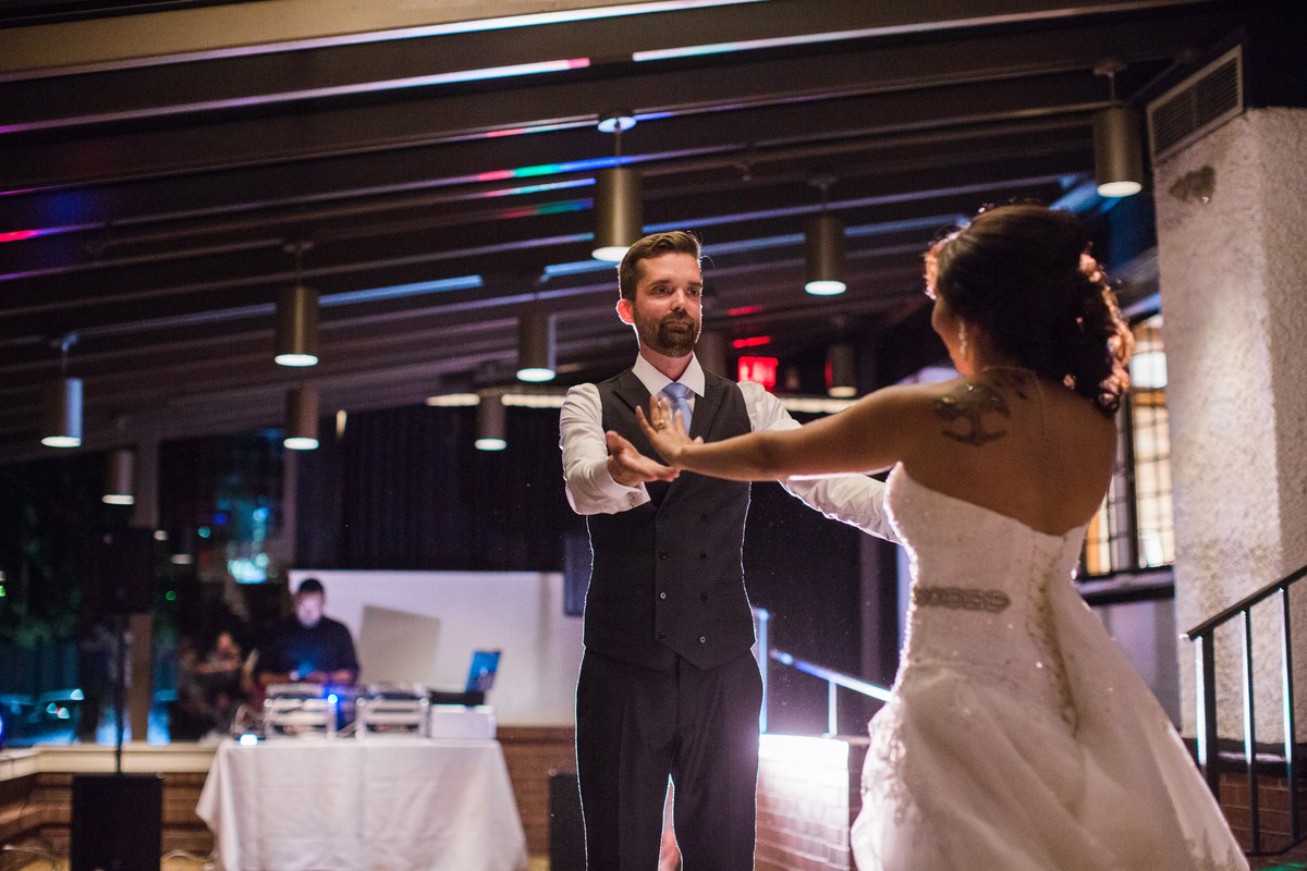 A wedding couple dancing with an open hand connection