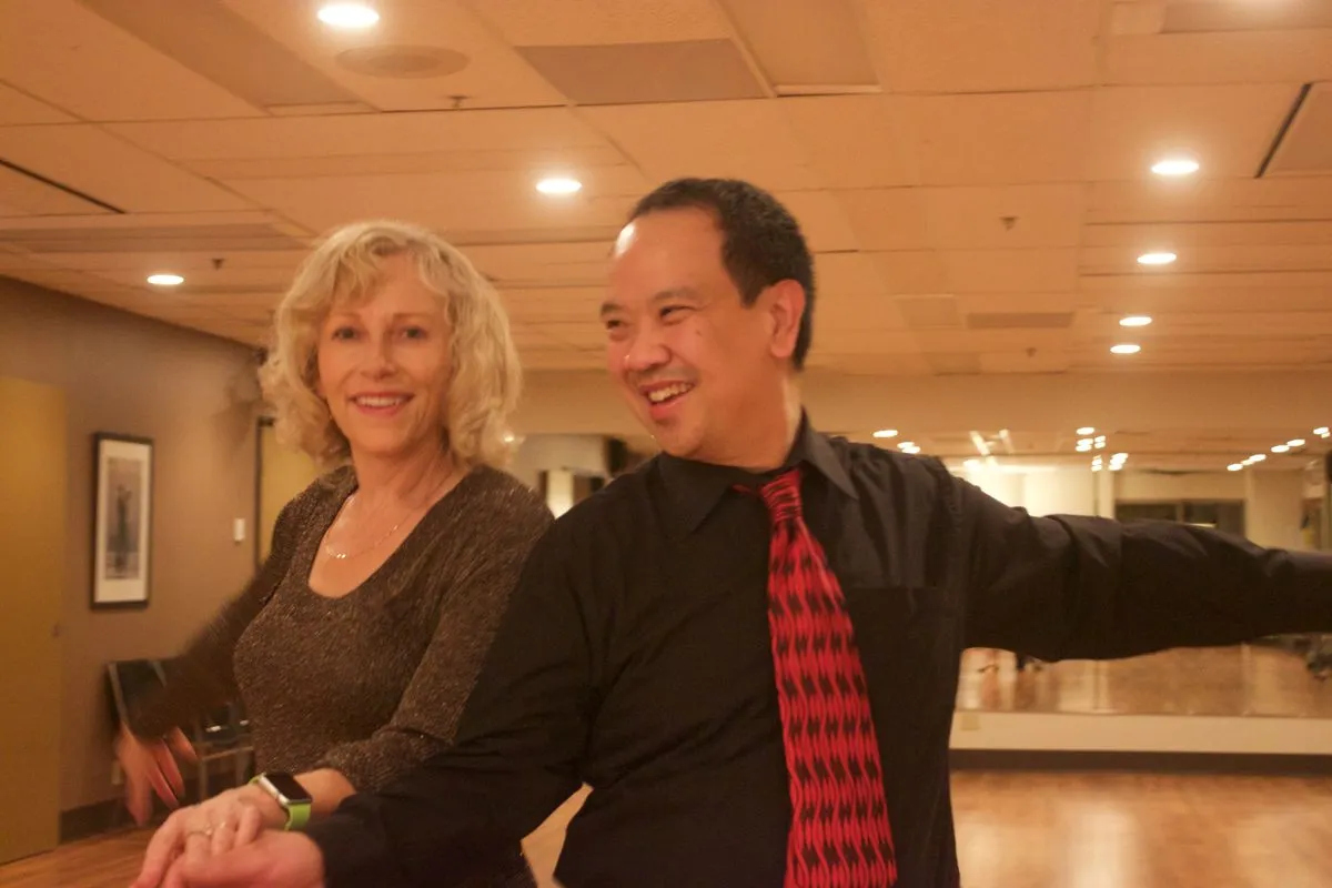 Two dance partners smiling together at a social dance event