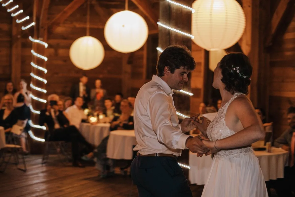 A wedding couple dancing under lanterns at their reception